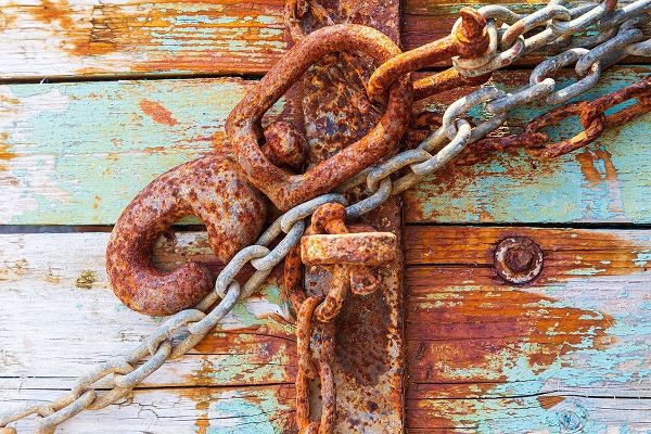 Rusty lock and chain on light blue wood